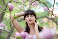 Woman in a blossoming spring magnolia garden