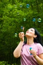 Woman blowing colorful soap bubbles Royalty Free Stock Photo