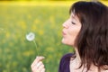 Woman blowing dandelion Royalty Free Stock Photo