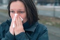 Woman blowing her nose into paper handkerchief Royalty Free Stock Photo