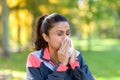 Woman blowing her nose on a tissue outdoors Royalty Free Stock Photo