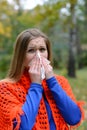 Woman blowing nose into tissue