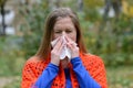 Woman blowing nose into tissue