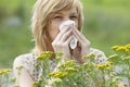 Woman blowing nose into tissue outdoors Royalty Free Stock Photo