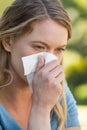 Woman blowing nose with tissue paper at park Royalty Free Stock Photo