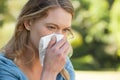 Woman blowing nose with tissue paper at park Royalty Free Stock Photo