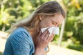 Woman blowing nose with tissue paper at park Royalty Free Stock Photo