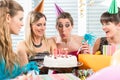 Woman blowing out candles on her birthday cake while celebrating Royalty Free Stock Photo