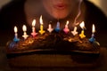 Woman is blowing out some colorful candles Royalty Free Stock Photo