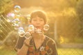 Woman blowing soap bubbles in the park Royalty Free Stock Photo