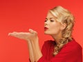 Woman blowing something on the palms of her hands Royalty Free Stock Photo