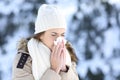 Woman blowing in a tissue in a cold snowy winter Royalty Free Stock Photo