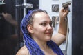 woman with blue afro hairstyle in the shower is washed with water.