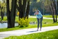 Woman in blue blazer doing leanings in the park Royalty Free Stock Photo