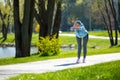 Woman in blue blazer doing leanings in the park