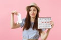 Woman in blue dress, hat holding sanitary napkin, tampon female periods calendar, checking menstruation days isolated on Royalty Free Stock Photo