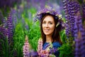 Woman in blue dress in purple lupines field. Meadow of violet flowers in the summer. Girl with long hair holding a lupine bouquet Royalty Free Stock Photo