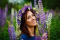 Woman in blue dress in purple lupines field. Meadow of violet flowers in the summer. Girl with long hair holding a lupine bouquet Royalty Free Stock Photo