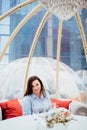 woman in a blue dress sits at tables in a cafe in the shape of a igloo on roof.