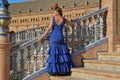 The woman in the blue flamenco dress, resting on the stairs Royalty Free Stock Photo