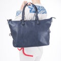 Woman with blue handbag in hands. Isolated white background. Royalty Free Stock Photo