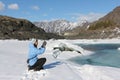 The woman in a blue jacket photographing the thawing river