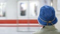 woman with blue jeans hat waiting train at station with blurred train door background Royalty Free Stock Photo