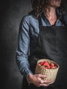 Woman in blue jeans shirt holding the basket full of strawberry Royalty Free Stock Photo