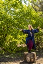 A woman in a blue kimono poses with a sword in the forest standing on a stump Royalty Free Stock Photo