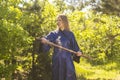 Woman in a blue kimono takes a sword from its scabbard in the forest Royalty Free Stock Photo