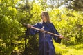 Woman in a blue kimono takes a sword from its scabbard in the forest Royalty Free Stock Photo