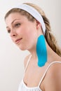 Woman with a blue kinesiology tape on neck.