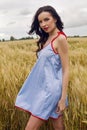 Woman in a blue light dress stands in a field Royalty Free Stock Photo