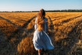 Woman in blue linen dress enjoying nature in sunset field. Stress and psychological resilience. Spend Time in Nature to