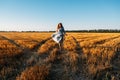 Woman in blue linen dress enjoying nature in sunset field. Stress and psychological resilience. Spend Time in Nature to