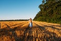 Woman in blue linen dress enjoying nature in sunset field. Stress and psychological resilience. Spend Time in Nature to