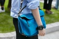 Woman with blue Loewe bag and Casio watch before Giorgio Armani fashion show, Milan Fashion Week street
