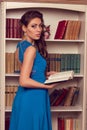 Woman in blue open back dress with lace reading book. Romantic