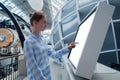 Woman touching interactive white touchscreen display kiosk at exhibition Royalty Free Stock Photo