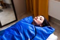 Woman in blue pressotherapy suit lying down having pressure therapy for weight loss in spa salon. Doctor help lose weight and