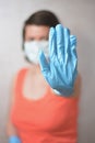 Woman with blue rubber glove make stop gesture Royalty Free Stock Photo