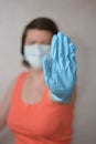 Woman with blue rubber glove make stop gesture. Royalty Free Stock Photo