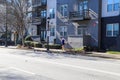 A woman in a blue shirt and black shorts running on the sidewalk in front of a black and gray apartment building in downtown