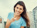 Woman in a blue shirt pointing at camera in cool cinema look Royalty Free Stock Photo