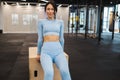 Woman in blue sportswear doing triceps exercises on wooden crossfit jump box at gym. Royalty Free Stock Photo