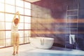 Woman in blue stone bathroom corner with tub Royalty Free Stock Photo