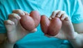 A woman in a blue t-shirt holds heart-shaped potatoes in her hands Royalty Free Stock Photo