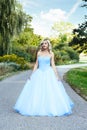 Woman in blue tulle dress on garden path