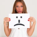 Woman with board sad emoticon face sign