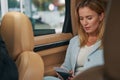 Woman with boarding ticket sitting in car